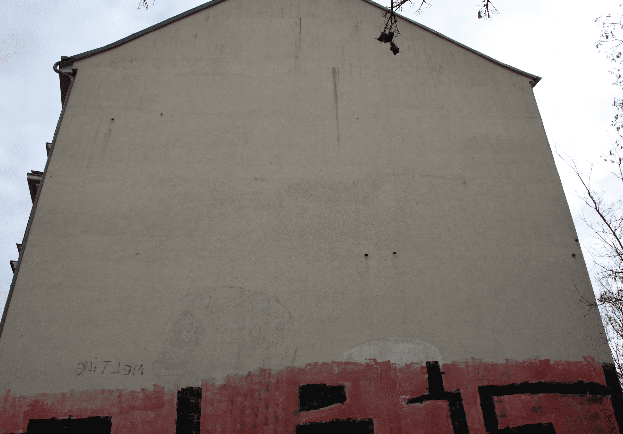 Viele Spechtlöcher in einer Hauswand